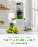 NAMA J2 Cold Press Juicer with green juice and apples on a kitchen counter, featuring Wired Magazine's 'Best All-Round Juicer' accolade.