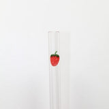 Clear glass tube with a strawberry decoration on a white background