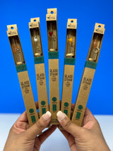 Five glass straws in packaging held by hands against a blue background